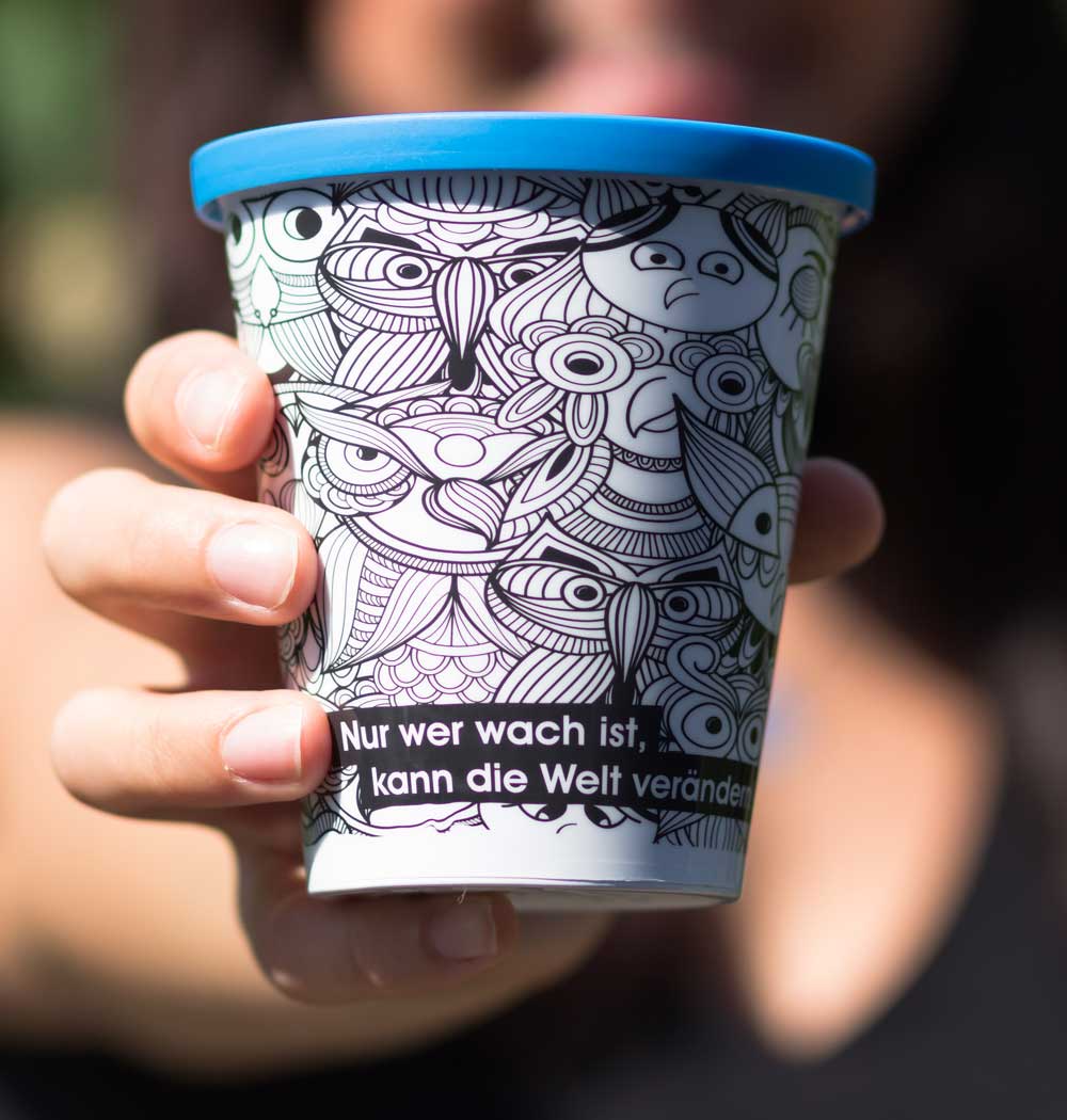 ORNAMIN-Mehrwegsystem-Coffee-to-go-Mehrwegbecher-Referenz-Studentenwerk-im-Saarland ORNAMIN Coffee to-go Mehrwegbecher im Eulenbecher Design wird in einer Hand gehalten
