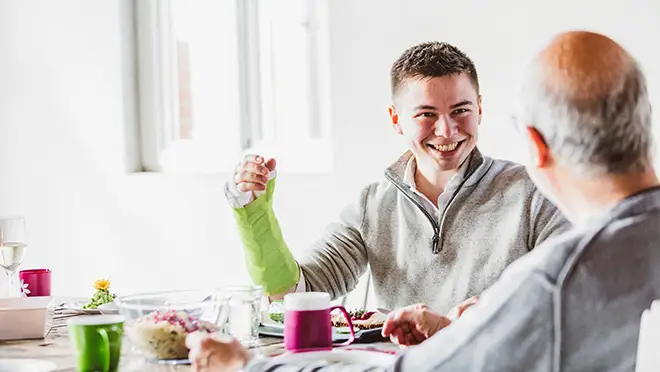 ORNAMIN-Pflegegeschirr-mit-Trick-für-die-häusliche-Pflege Zwei-pflegebedürftige-Personen-essn-und-trinken-zuhause-am-Tisch-mit-ORNAMIN-Pflegegeschirr