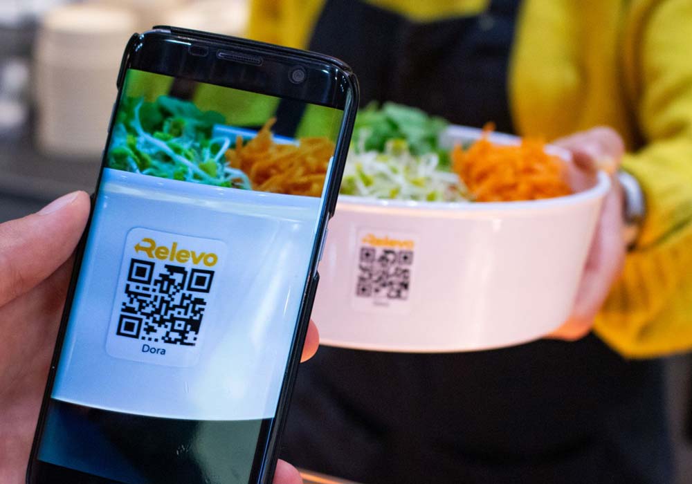 ORNAMIN-Mehrwegsystem-Food-to-go-Mehrwegschalen-Referenz-Relevo-Mensa-Regensburg Der Barcode einer ORNAMIN To-go Mehrwegschalen im Einsatz Relevo Mehrwegsystem wird per Handy gescannt