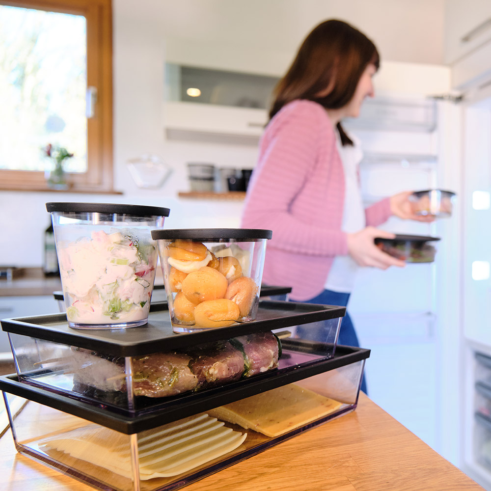 Frau stellt ORNAMIN Mehrwegschalen in den Kühlschrank