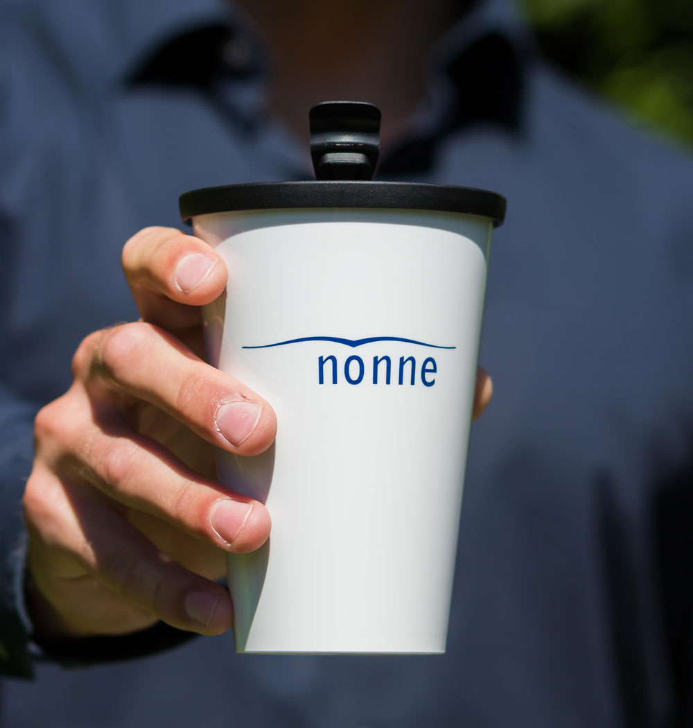 ORNAMIN-Mehrwegsystem-für-Unternehmen-Coffee-to-go-Referenz-Erich-Nonne ORNAMIN Coffee to-go Mehrwegbecher in Design von Erich-Nonne wird in einer Hand gehalten