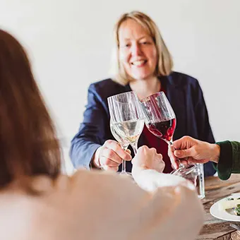 Drei Personen stoßen mit ORNAMIN Weingläsern an