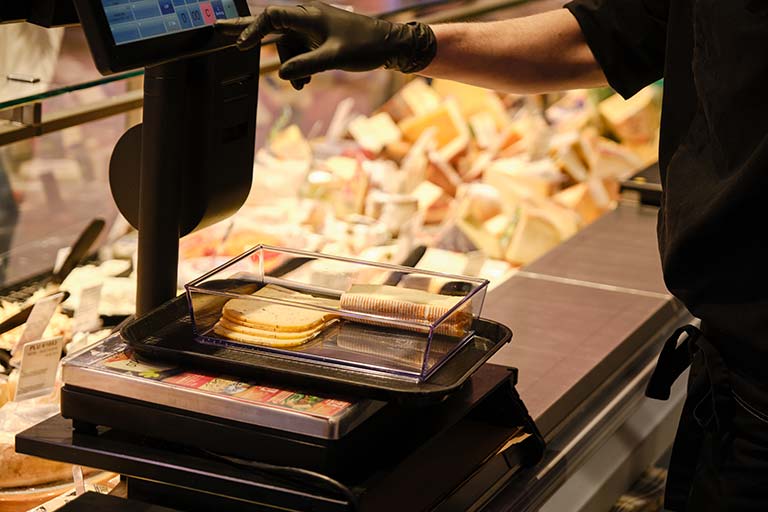 Man wiegt Käse in ORNAMIN Schale ab