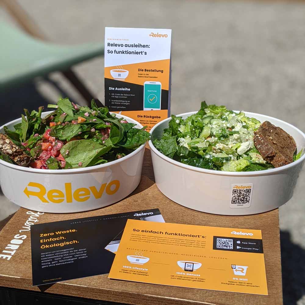 ORNAMIN-Mehrwegsystem-Food-to-go-Mehrwegschalen-Referenz-Relevo Zwei ORNAMIN To-go Mehrwegschalen im Einsatz-im Relevo Mehrwegsystem-gefüllt mit Take Away Gerichten
