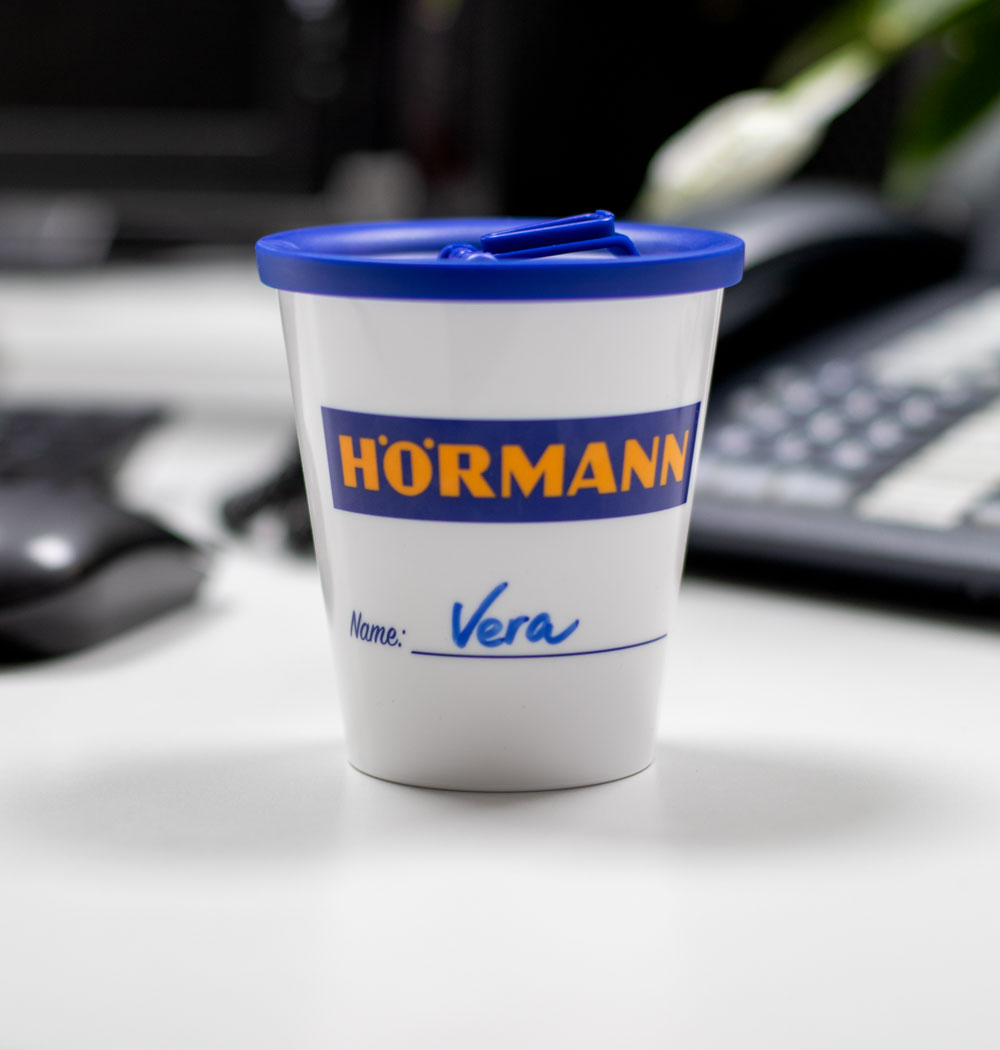 ORNAMIN-Coffee-to-go-Mehrwegbecher-im-Design-von-Hoermann-bechriftet-mit-dem-Namen-einer-Mitarbeiterin