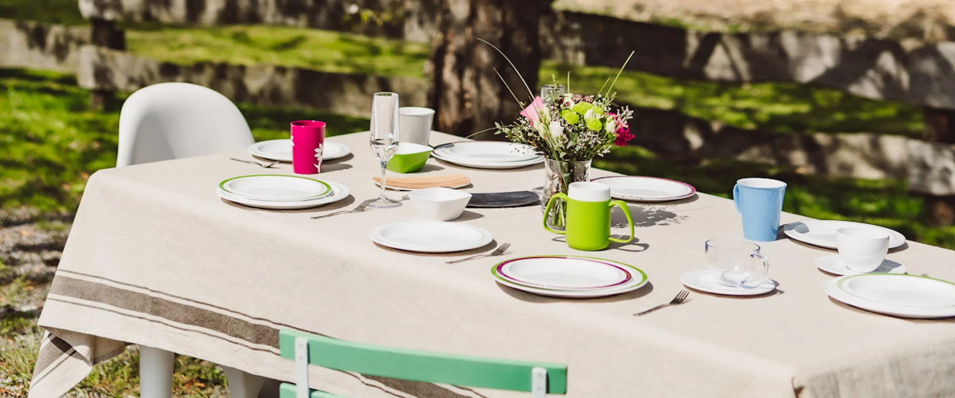 ORNAMIN Farbenfrohes Geschirr Ein bunt gedeckter Gartentisch. A colourfully set garden table.