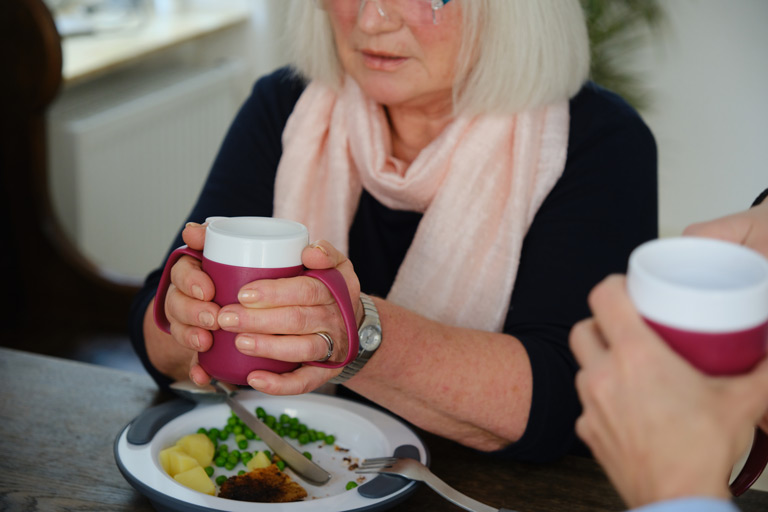 Frau trinkt aus einem Ornamin Henkelbecher