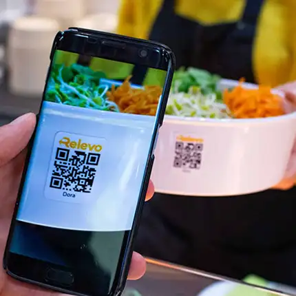 Barcode einer ORNAMIN Mehrwegschale im Relevo Mehrwegsystem wird per Handy gescannt